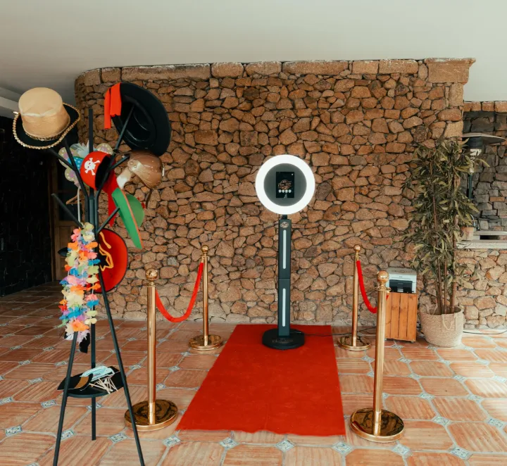 Photobooth com anel de luz, passadeira vermelha, baias douradas e cabide com adereços